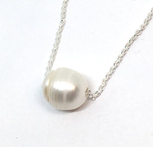 Single white pearl on a silver chain